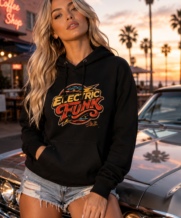 A woman wearing a black pullover hoodie with a colorful 'Electric Funk' graphic on the front, posing next to a classic car in front of a sunset with palm trees.
